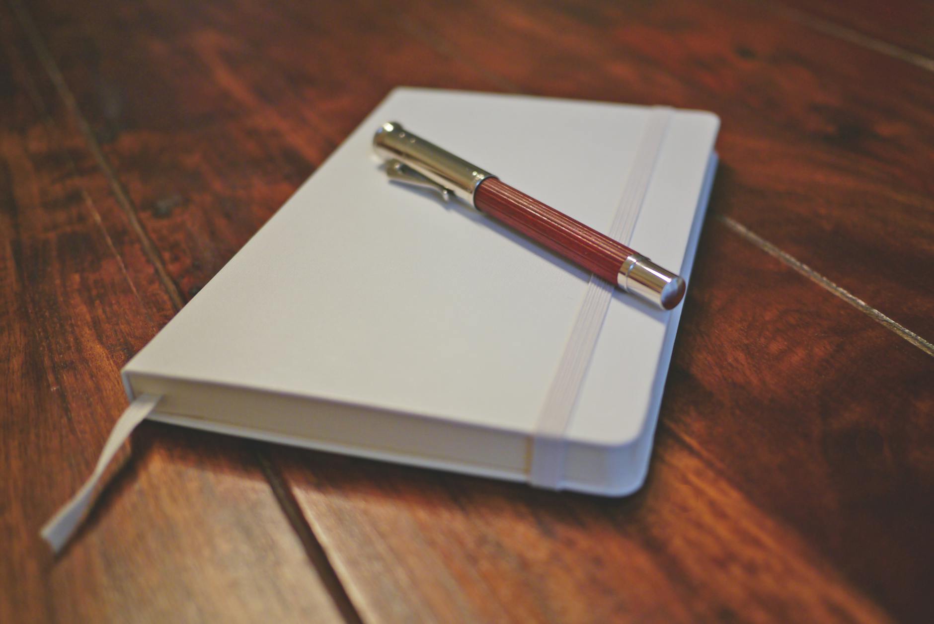 brown pen on white notebook